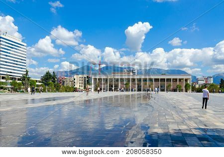 TIRANA ALBANIA - SEPTEMBER 6 2017: National Opera and Ballet Theater of Albania Tirana International Hotel. Unidentified people walk on Skanderbeg Square Tirana