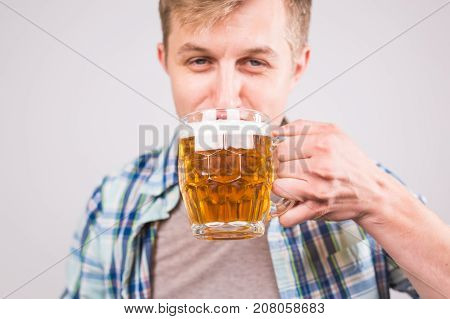 Man drinking beer. Happy young man holding a beer mug.