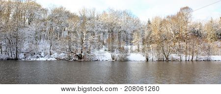 Frosty tree in the winter scenery . Winter tree against with reflection in water.