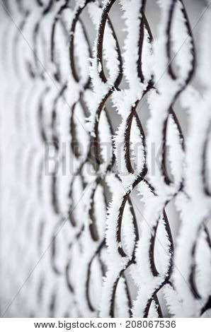 Fence background covered with frost and snow