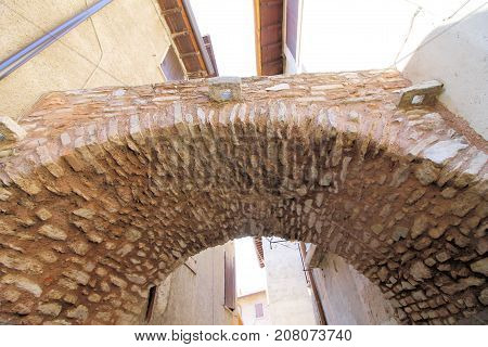 architectural detail of a small bridge between two ancient houses in a small village in Italy