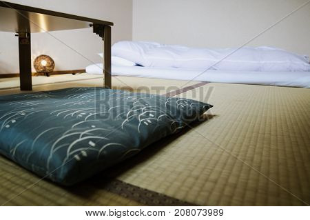 Traditional Japanese Ryokan room with tatimi mats and futon, pillow and table, Japan