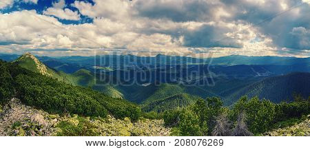 Carpathian mountains summer landscape with dramatic clouds and mossy stones. Panoramic view
