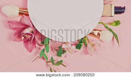 Decorative flat lay composition with makeup products, cosmetics and flowers. Flat lay, top view on pink background. Copytext