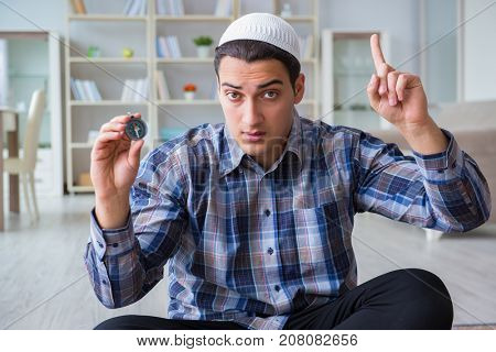 Young muslim man praying at home