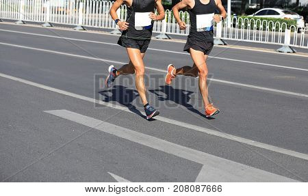 closeup of marathon runners running on city road