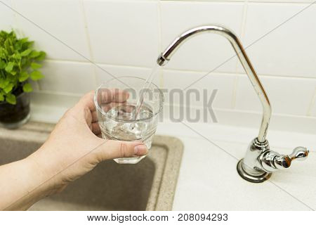 Clear transparent cold water flows from the tap