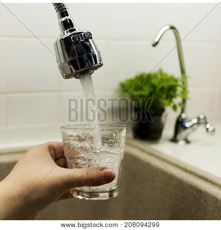 Clear transparent cold water flows from the tap