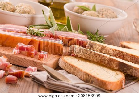 Canederli pasta with bacon on wooden table.