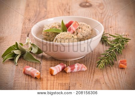 Canederli pasta with bacon on wooden table.
