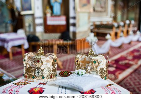 Close-up Photo Of Wedding Crowns In The Church On The Table.
