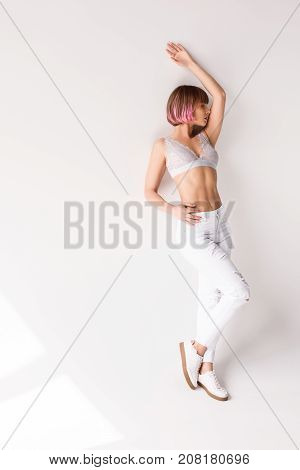 Woman In Bralette Leaning On Wall