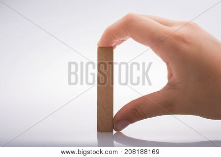 Hand Holding Wooden Domino