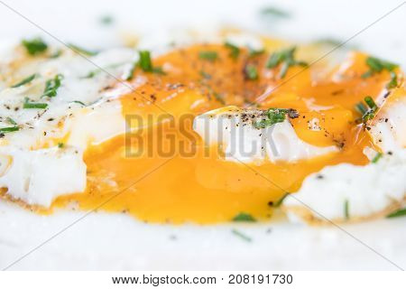 Closeup, Fried Egg With Fluidly And Liquid Egg Yolk On A White Plate