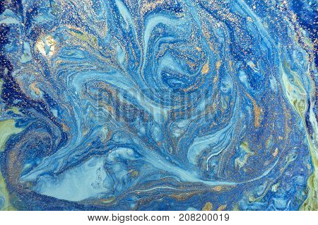 Marbled blue abstract background with golden sequins. Liquid marble ink pattern