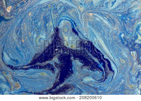 Marbled blue abstract background with golden sequins. Liquid marble ink pattern