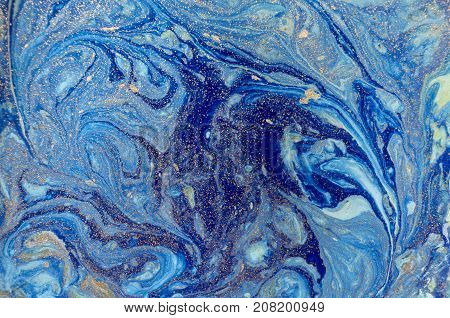 Marbled blue abstract background with golden sequins. Liquid marble ink pattern
