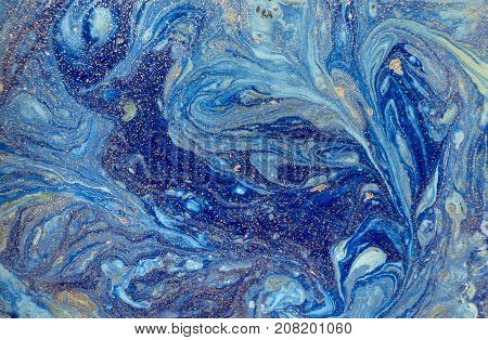 Marbled blue abstract background with golden sequins. Liquid marble ink pattern