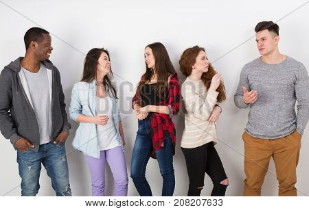 Education concept. Group of diverse students in casual outfits standing in line on white studio background