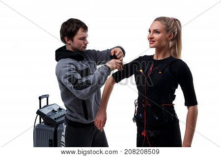 Trainer helps woman attaching electrode on ems suit isolated on white background