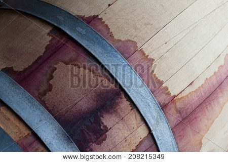 front view closeup of a wine oak wood barrel texture stained with red tannins