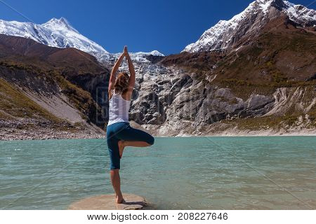 Woman Is Doing Yoga Excercises Near Big Lake On The Manaslu Circuit Trak In Nepala