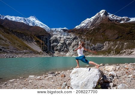 Woman Is Doing Yoga Excercises Near Big Lake On The Manaslu Circuit Trak In Nepala