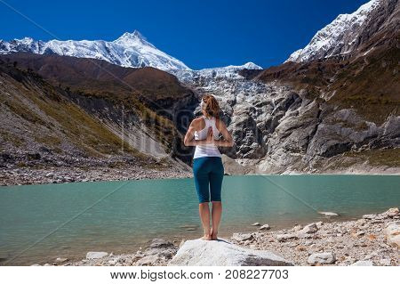 Woman Is Doing Yoga Excercises Near Big Lake On The Manaslu Circuit Trak In Nepala