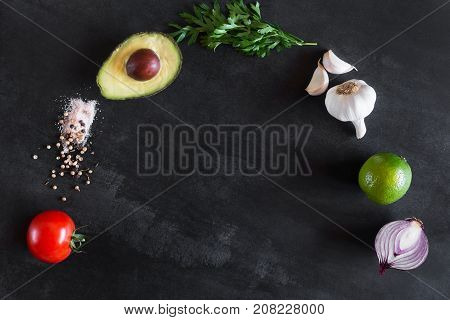 Guacamole ingredients on the dark chalkboard with copy space