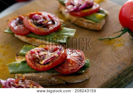 Summer sandwich prepared with fried red onion, tomato and kidney beans. Top view