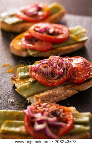 Summer sandwich prepared with fried red onion, tomato and kidney beans. Vertical orientation