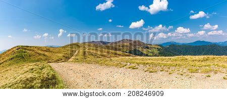 panoramic view of path through the mountain ridge. spectacular landscape in early autumn weather with fluffy clouds on the blue sky