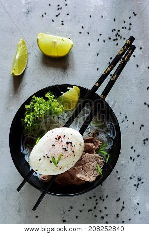 Vietnamese soup with beef noodles and poached egg. Eastern cuisine. Spicy lunch. Fo bo. Asian cuisine.