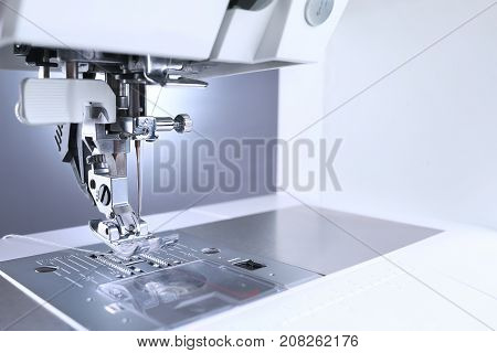 Sewing machine close up. Sewing machine foot and sewing accessories.