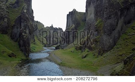 flying through the drone through the canyon Fjarrgljfur and the river going inside it on a sunny day in southern Iceland