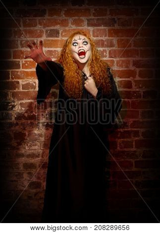 Scary witch on brick wall background