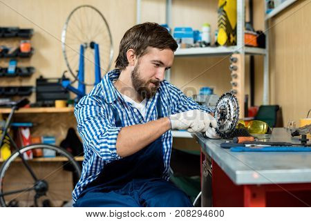 Young repairman doing his work in bicycle store
