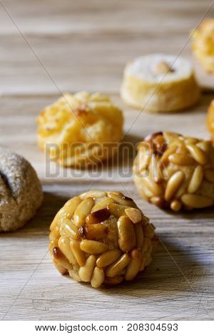 closeup of some panellets, typical confection eaten in All Saints Day in Catalonia, Spain, on a wooden table