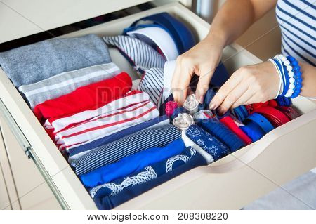 Neatly Folded Clothes With Accessories In Chest Of Drawers. Marine Clothing Style