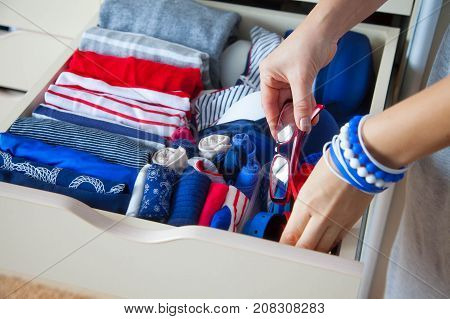 Neatly Folded Clothes With Accessories In Chest Of Drawers. Marine Clothing Style