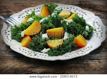 Healthy beet salad with fresh kale lettuce, nuts, feta cheese on wooden background .