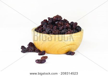 black raisins isolated on white and wooden background