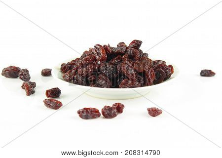 black raisins isolated on white and wooden background