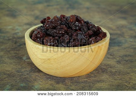 black raisins isolated on white and wooden background