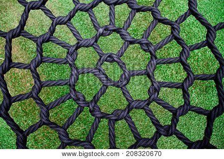 A black soccer net on green grass