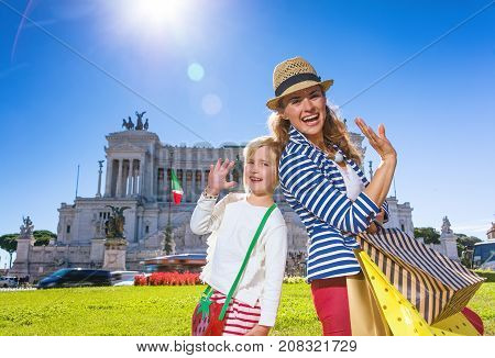 Roman Holiday. happy modern mother and daughter travellers in Rome Italy with shopping bags handwaving
