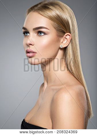 Profile portrait of  a beautiful young woman with long light straight  hair.