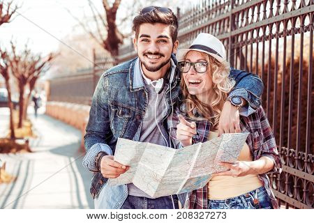 Loving couple with a map looking for an address on the strreet.