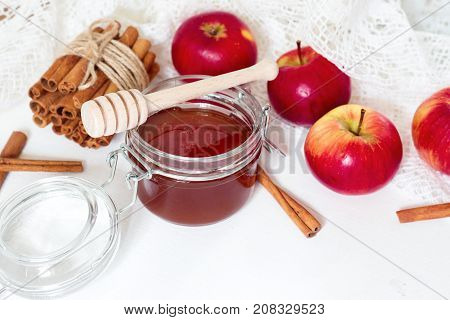 honey spoon jar of honey apples and cinnamon on a wooden background in a rustic style (toning)