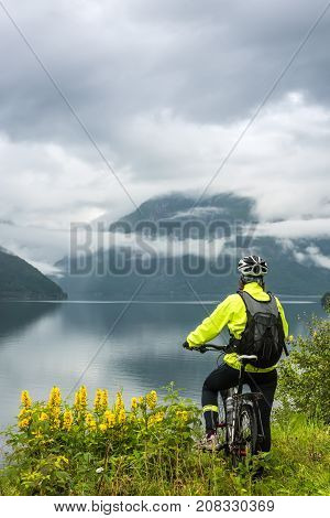 Mountain bike cyclist near fjord, summer Norway